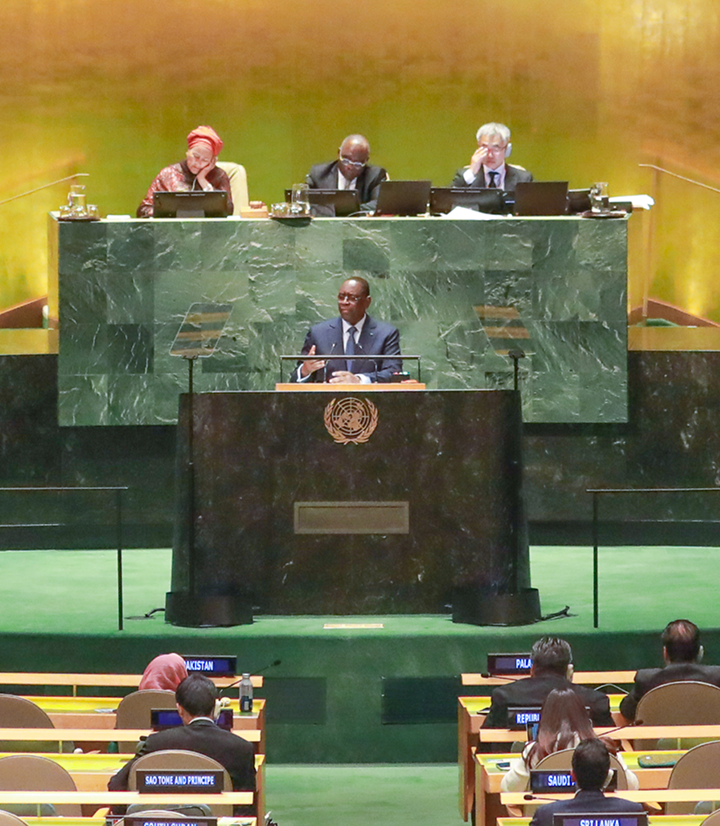 Two women sitting at a modern table talking with a city view behind them.
